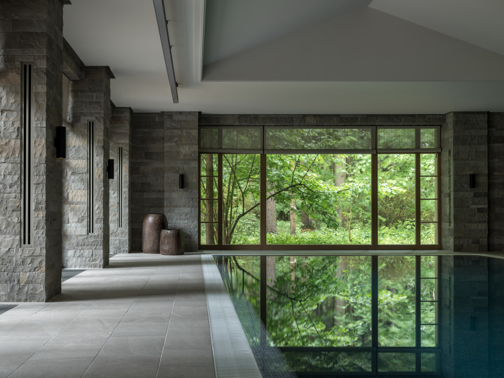 На фото: огромный прямоугольный бассейн-инфинити в доме в современном стиле с покрытием из плитки с