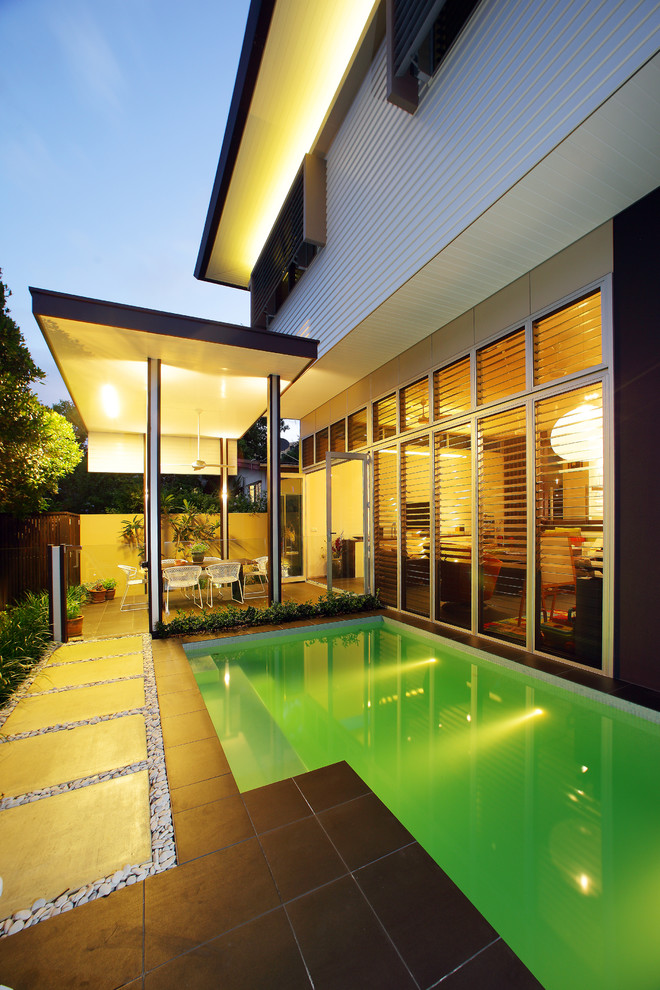 Design ideas for a mid-sized modern side yard rectangular lap pool in Gold Coast - Tweed with a pool house and concrete pavers.