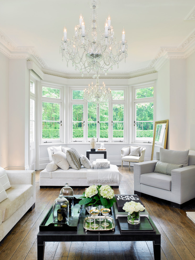 This is an example of a traditional living room in London with white walls and medium hardwood floors.