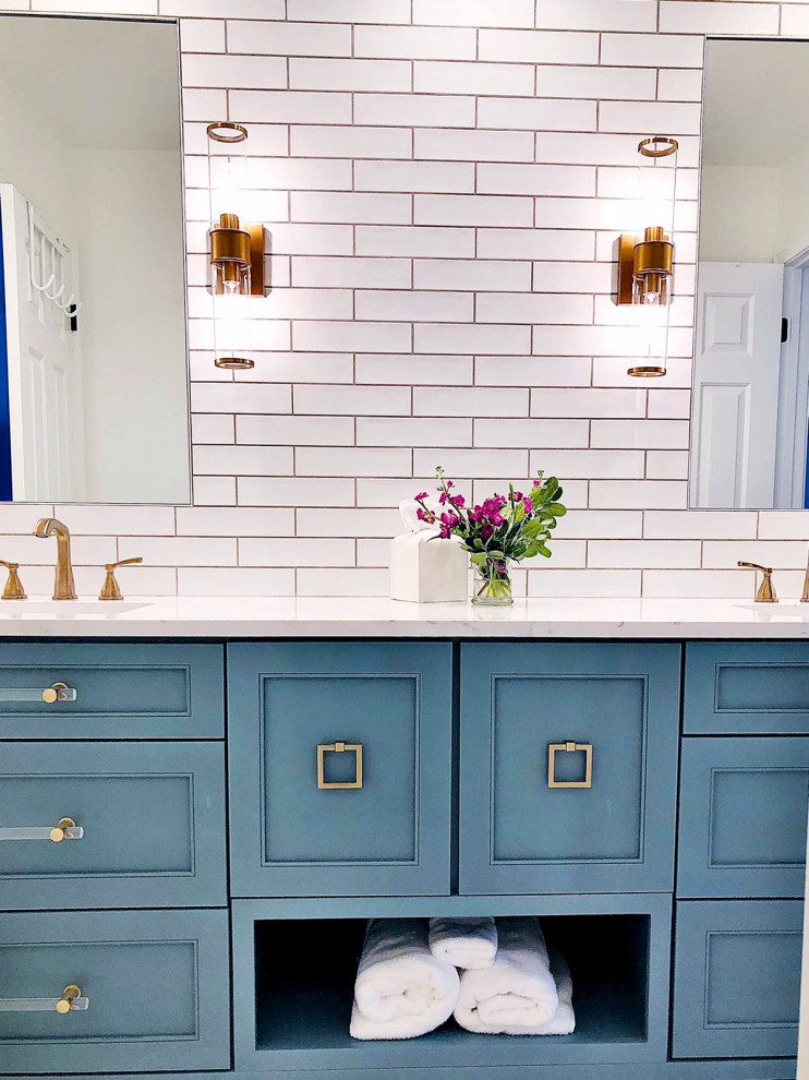 Inspiration for a mid-sized traditional 3/4 bathroom in Atlanta with open cabinets, blue cabinets, an alcove tub, a shower/bathtub combo, a one-piece toilet, white tile, subway tile, white walls, marble floors, an undermount sink, engineered quartz benchtops, white floor, a hinged shower door, white benchtops, a double vanity, a built-in vanity and planked wall panelling.