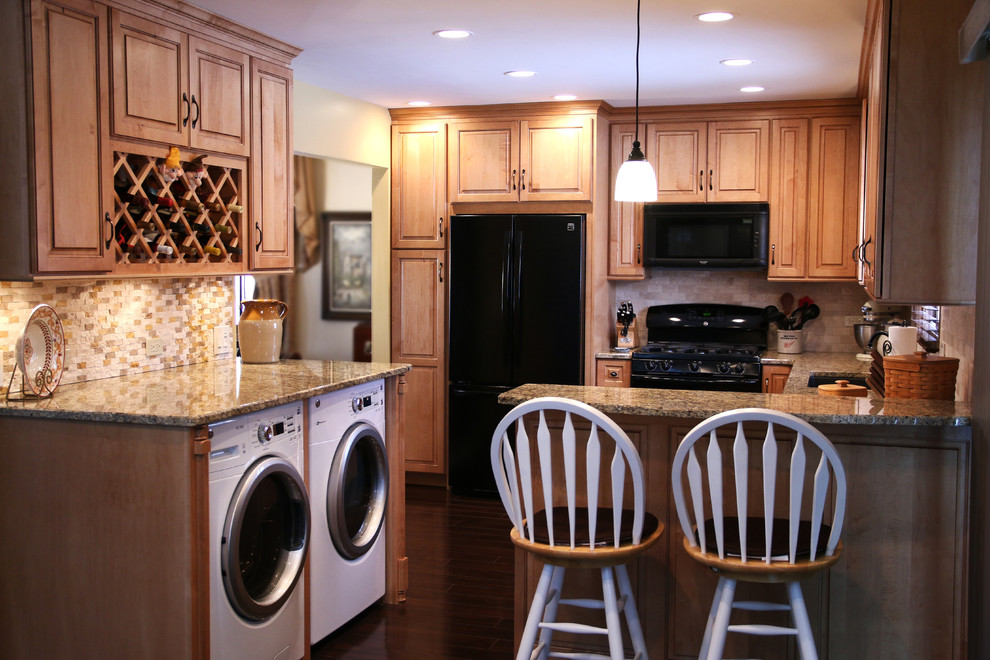 Inspiration for a small transitional u-shaped laminate floor open concept kitchen remodel in Chicago with an undermount sink, raised-panel cabinets, medium tone wood cabinets, granite countertops, beige backsplash, subway tile backsplash, black appliances, black walls and a peninsula