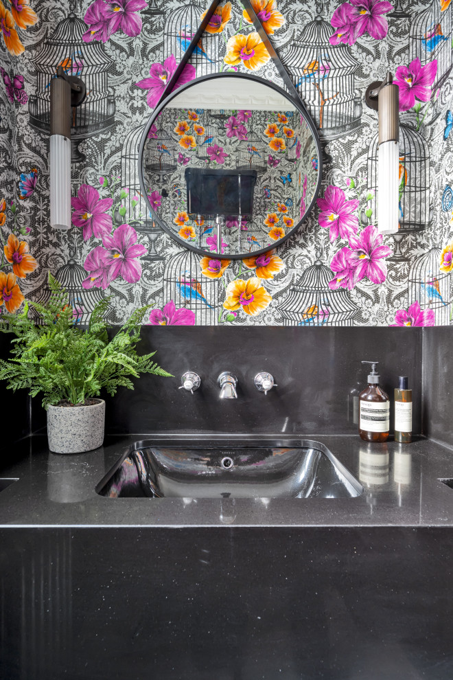 Inspiration for a mid-sized contemporary powder room in London with grey cabinets, gray tile, porcelain tile, multi-coloured walls, ceramic floors, an integrated sink, concrete benchtops, grey floor, grey benchtops, a built-in vanity and wallpaper.