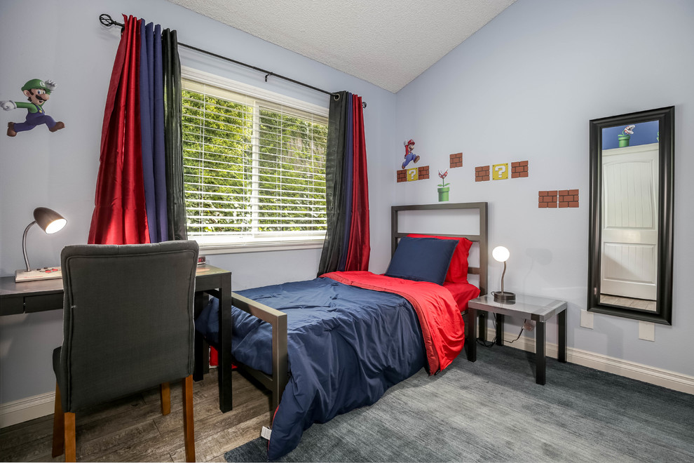 This is an example of an industrial kids' bedroom for kids 4-10 years old and boys in Los Angeles with blue walls, laminate floors and grey floor.