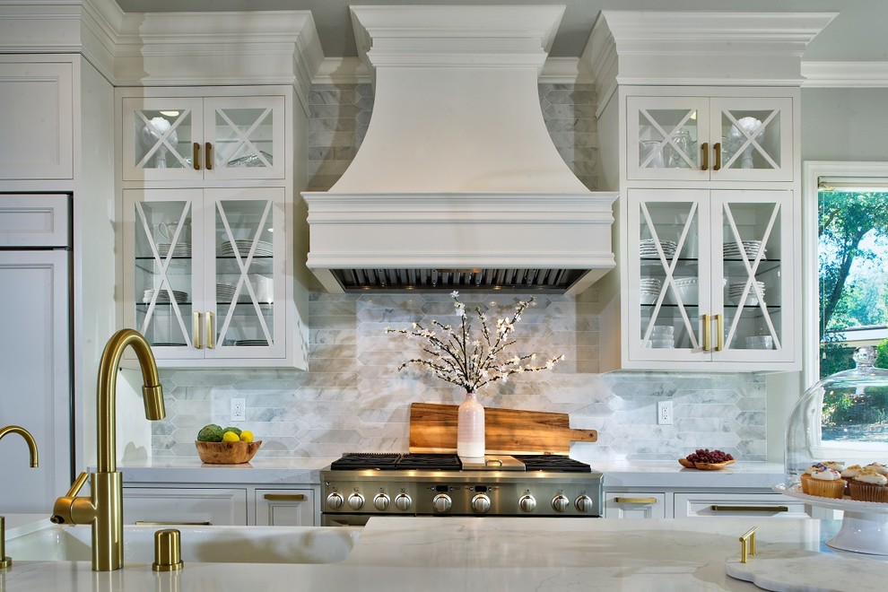 Mid-sized transitional u-shaped light wood floor eat-in kitchen photo in Sacramento with a farmhouse sink, white cabinets, gray backsplash, stainless steel appliances, an island and white countertops