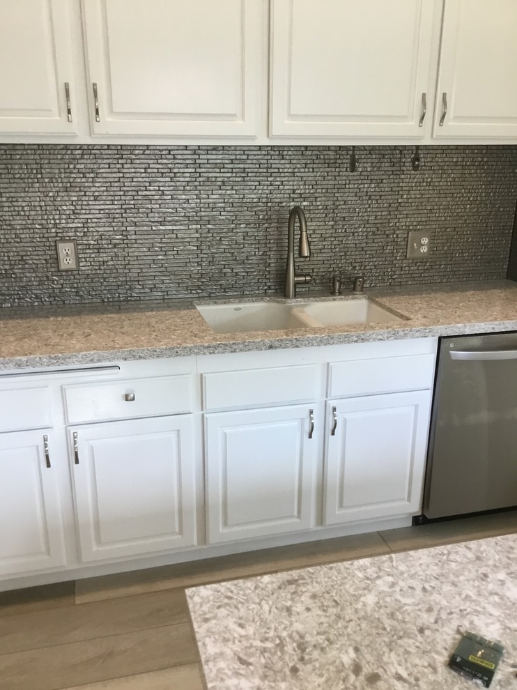 Kitchen - small transitional kitchen idea in Orange County with metallic backsplash, glass sheet backsplash and gray countertops
