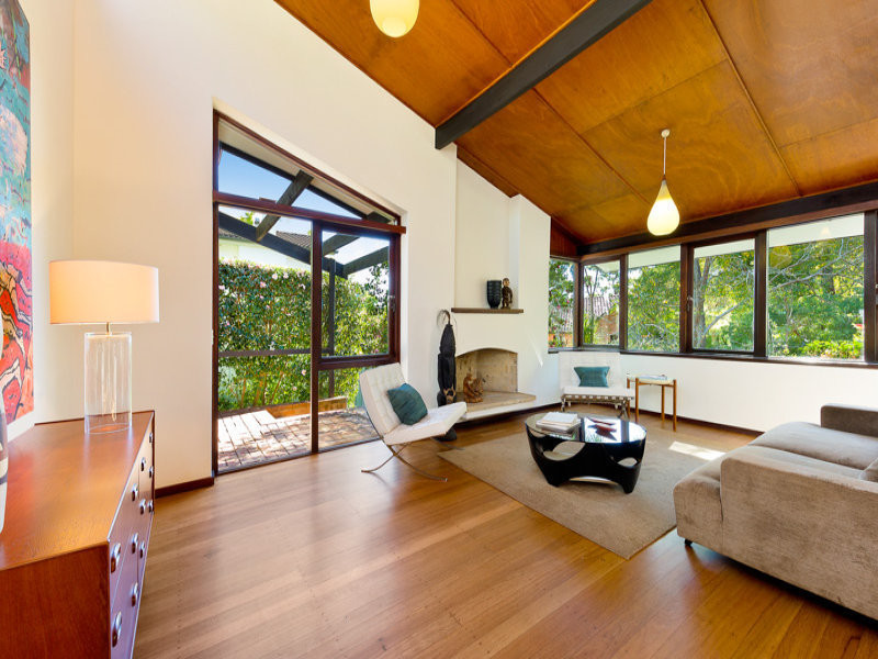 Mid-sized midcentury open concept living room in Sydney with light hardwood floors, a standard fireplace and a plaster fireplace surround.