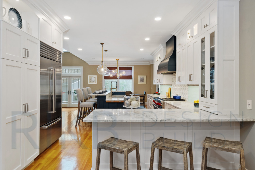 Eat-in kitchen - large transitional l-shaped light wood floor and brown floor eat-in kitchen idea in Providence with an undermount sink, shaker cabinets, white cabinets, quartzite countertops, white backsplash, stainless steel appliances, an island and white countertops
