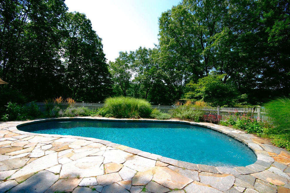 Large mountain style backyard stone and kidney-shaped natural pool photo in New York