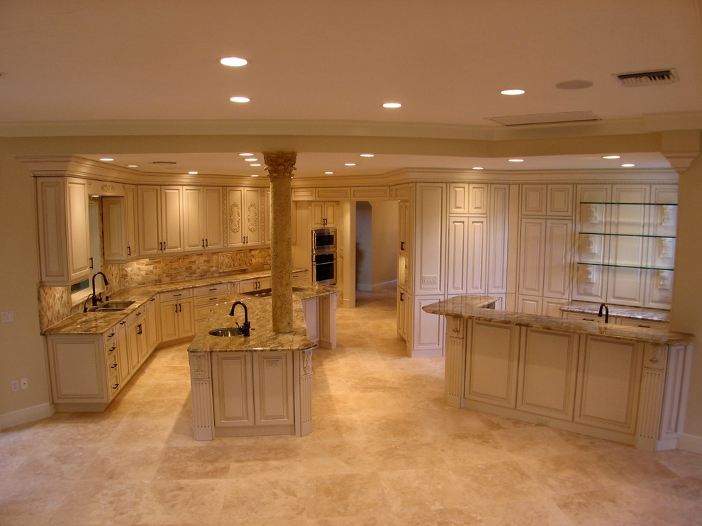 Design ideas for a large mediterranean open plan kitchen in Tampa with an undermount sink, recessed-panel cabinets, beige cabinets, granite benchtops, beige splashback, panelled appliances, marble floors and with island.