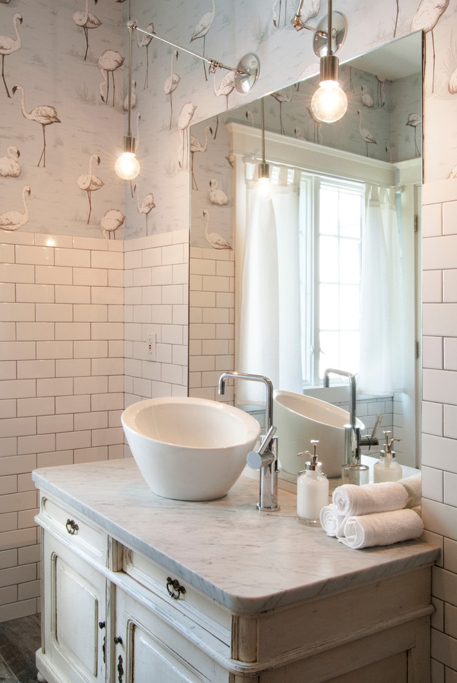 Mid-sized eclectic bathroom in Cleveland with a vessel sink, distressed cabinets, marble benchtops, white tile, subway tile, multi-coloured walls, ceramic floors and raised-panel cabinets.