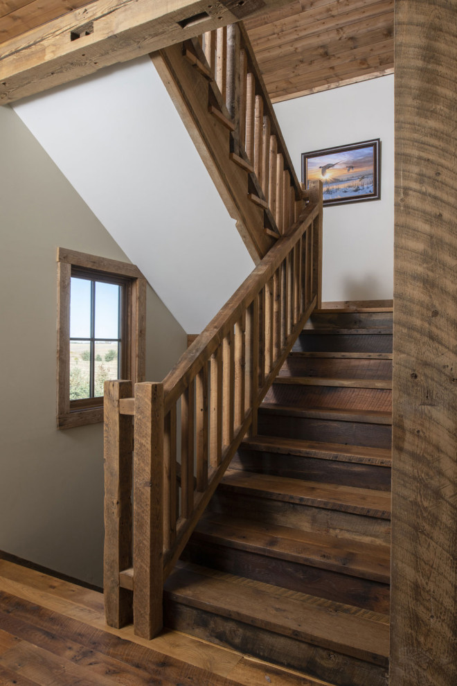 This is an example of a rustic wood l-shaped wood railing staircase in Minneapolis with wood risers.