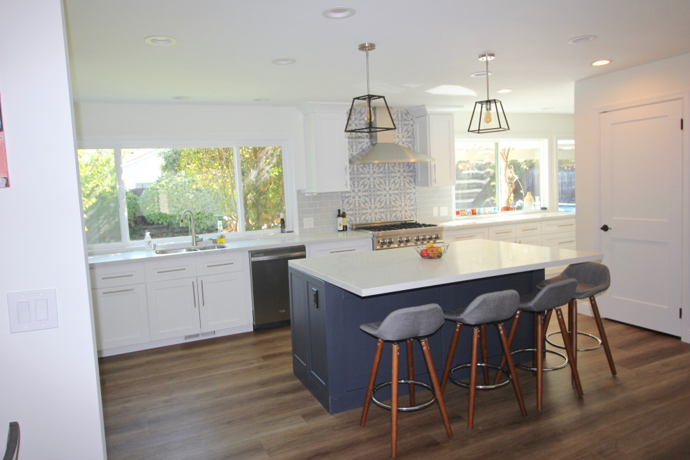 Design ideas for a large transitional l-shaped open plan kitchen in San Francisco with an undermount sink, shaker cabinets, white cabinets, quartz benchtops, blue splashback, ceramic splashback, stainless steel appliances, vinyl floors, with island, brown floor and grey benchtop.