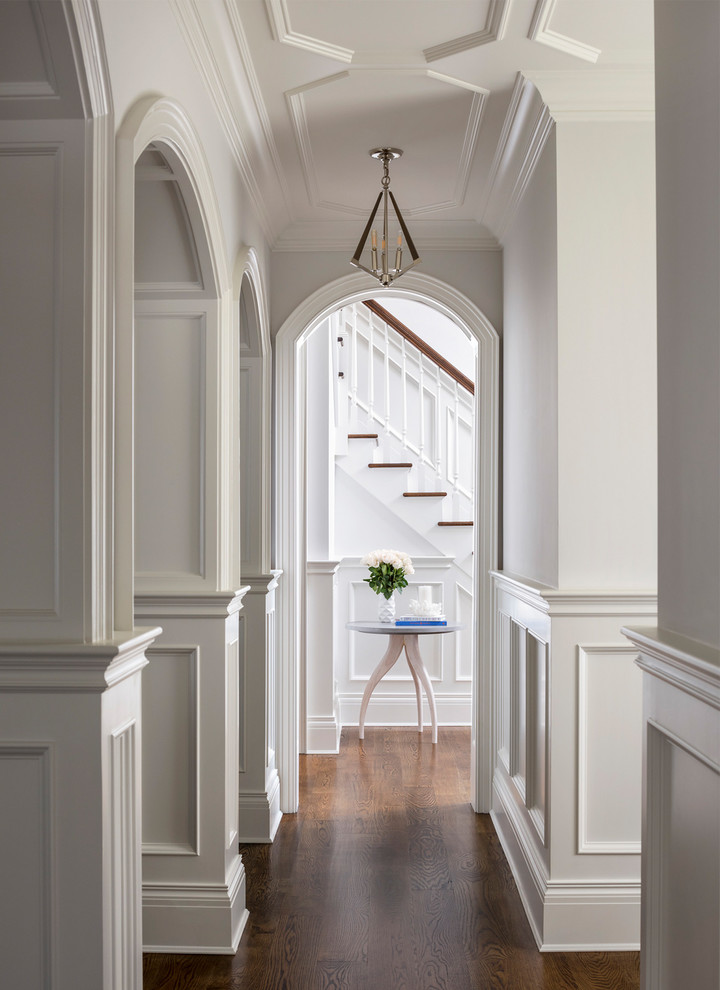 Design ideas for a traditional hallway in New York with white walls, medium hardwood floors and brown floor.