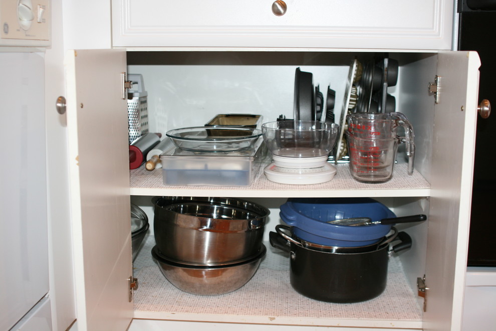 Mid-sized transitional u-shaped medium tone wood floor kitchen photo with glass-front cabinets, white cabinets, laminate countertops and a peninsula