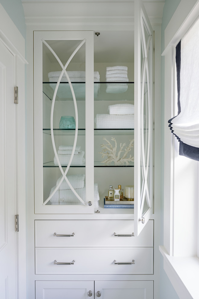 Design ideas for a small transitional master bathroom in Portland with glass-front cabinets, white cabinets, blue walls, porcelain floors and white floor.