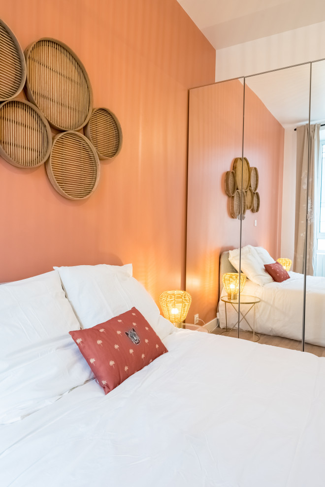 Modelo de dormitorio minimalista pequeño con parades naranjas y suelo de madera en tonos medios
