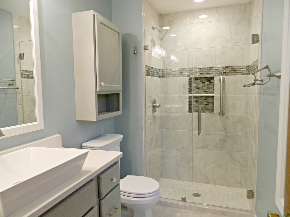 Design ideas for a mid-sized transitional 3/4 bathroom in Other with shaker cabinets, grey cabinets, an alcove shower, a one-piece toilet, gray tile, stone tile, blue walls, porcelain floors, a vessel sink and engineered quartz benchtops.