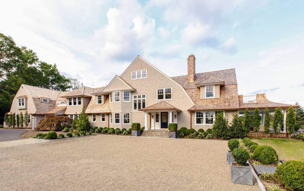 Photo of an expansive beach style two-storey grey house exterior in New York with wood siding, a gambrel roof and a shingle roof.