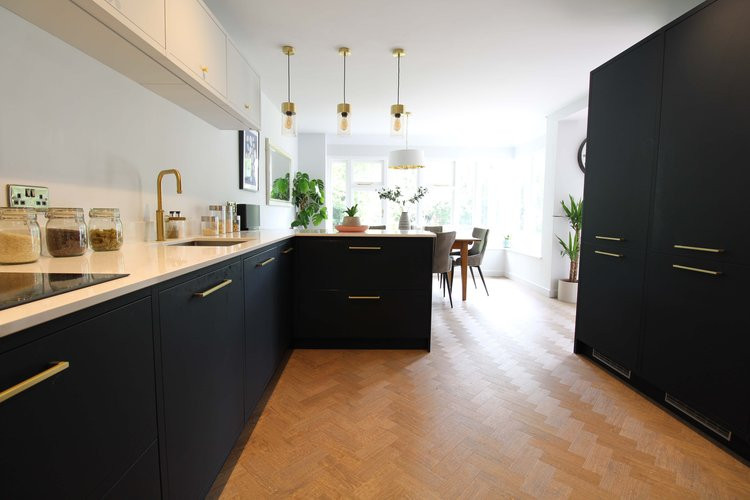 Inspiration for a medium sized contemporary l-shaped open plan kitchen in Cambridgeshire with a double-bowl sink, shaker cabinets, blue cabinets, marble worktops, white splashback, marble splashback, black appliances, vinyl flooring, an island, beige floors and white worktops.