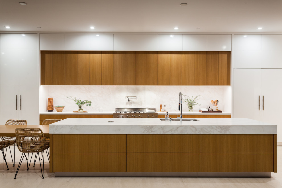 Inspiration for an expansive contemporary galley kitchen in Orange County with flat-panel cabinets, medium wood cabinets, with island, white benchtop, an undermount sink, marble benchtops, white splashback, marble splashback, marble floors and beige floor.