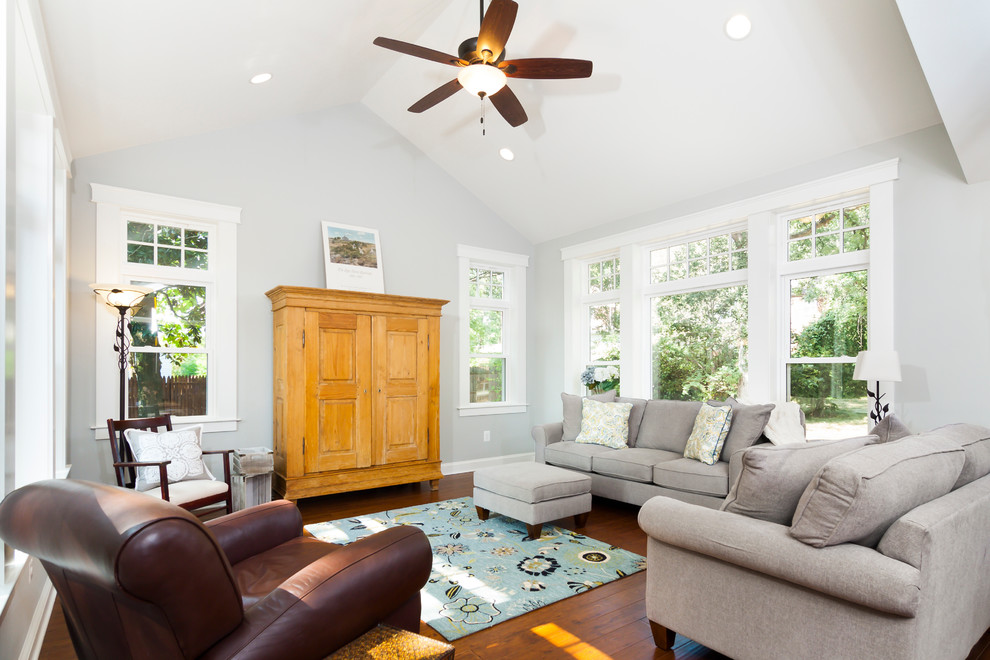 This is an example of a mid-sized arts and crafts open concept family room in DC Metro with grey walls, no fireplace, a concealed tv and medium hardwood floors.