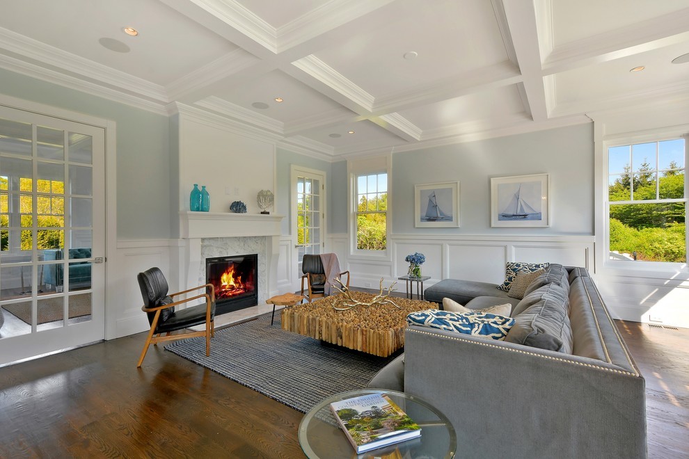 Photo of a large traditional enclosed living room in New York with blue walls, medium hardwood floors, a standard fireplace and a tile fireplace surround.