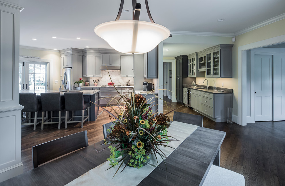 Inspiration for a large transitional single-wall dark wood floor eat-in kitchen remodel in Boston with an undermount sink, flat-panel cabinets, gray cabinets, granite countertops, white backsplash, ceramic backsplash, stainless steel appliances and an island