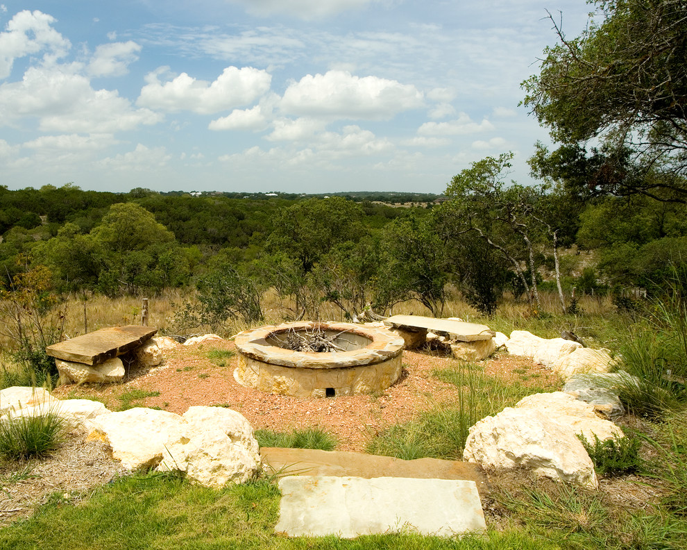 Design ideas for an expansive mediterranean backyard custom-shaped natural pool in Austin with a water feature and natural stone pavers.
