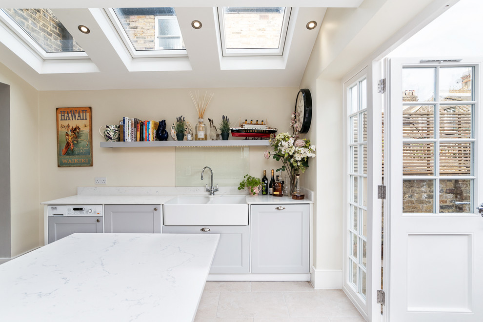 This is an example of a mid-sized transitional galley eat-in kitchen in London with with island.
