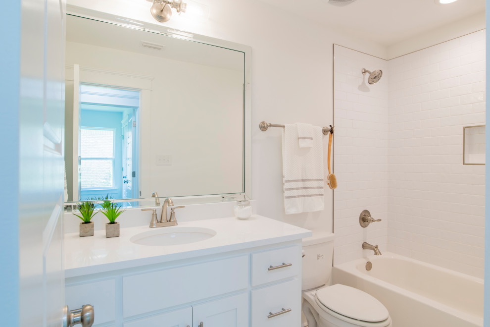 White tile and subway tile single-sink bathroom photo with shaker cabinets, blue cabinets, an undermount sink, granite countertops, white countertops and a built-in vanity