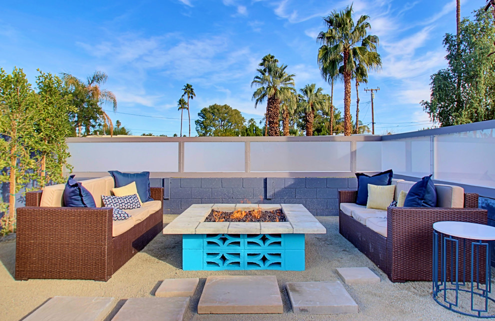 Large midcentury patio in Phoenix with a fire feature, decomposed granite and no cover.