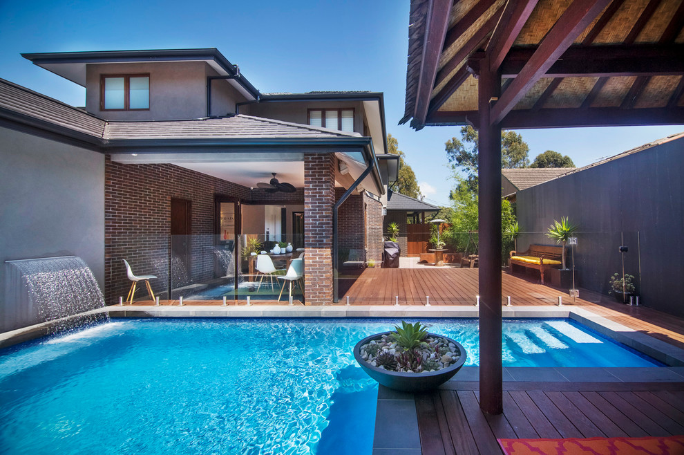 Design ideas for a large contemporary backyard pool in Melbourne with concrete pavers.