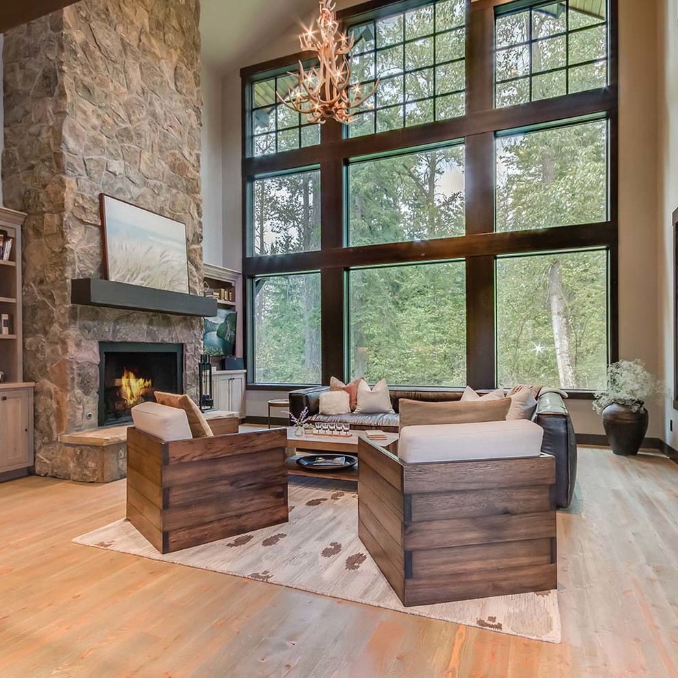 Inspiration for a mid-sized country formal open concept living room in Other with grey walls, medium hardwood floors, a standard fireplace, a stone fireplace surround, a wall-mounted tv and brown floor.