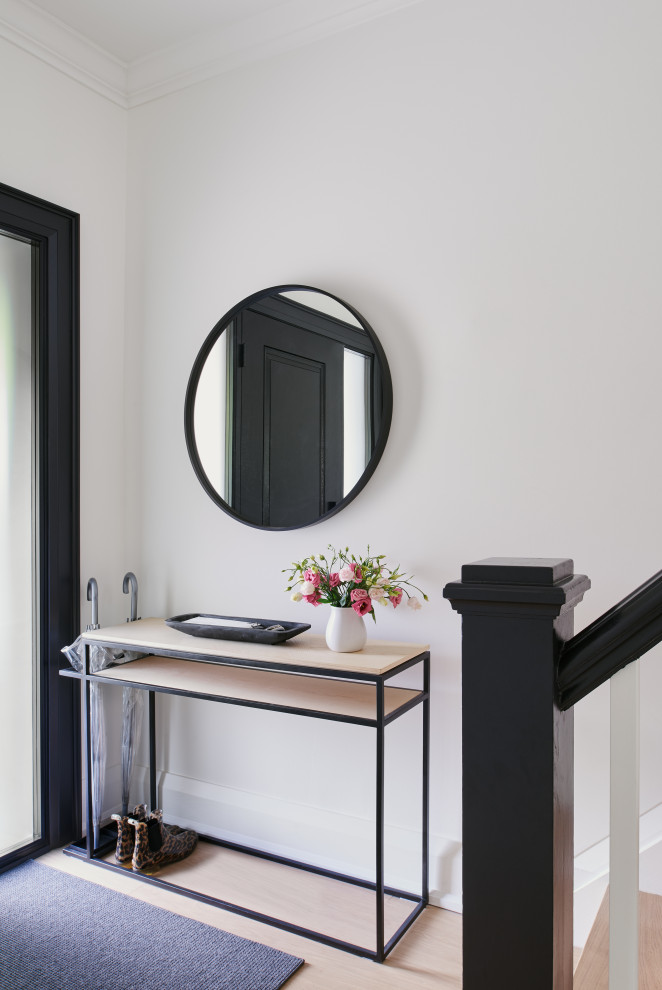 Entryway - transitional light wood floor entryway idea in Toronto with white walls