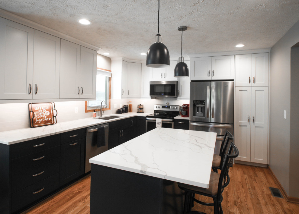 Inspiration for a mid-sized transitional u-shaped kitchen pantry remodel with an undermount sink, shaker cabinets, blue cabinets, quartz countertops, stainless steel appliances and an island