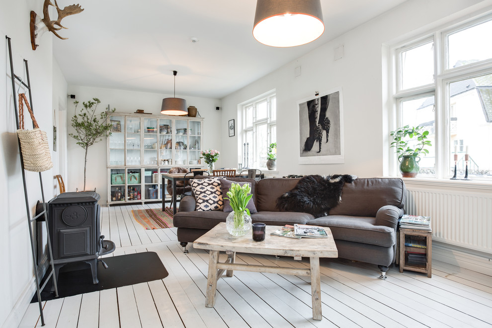 This is an example of a large scandinavian formal open concept living room in Malmo with white walls, painted wood floors, no fireplace and no tv.