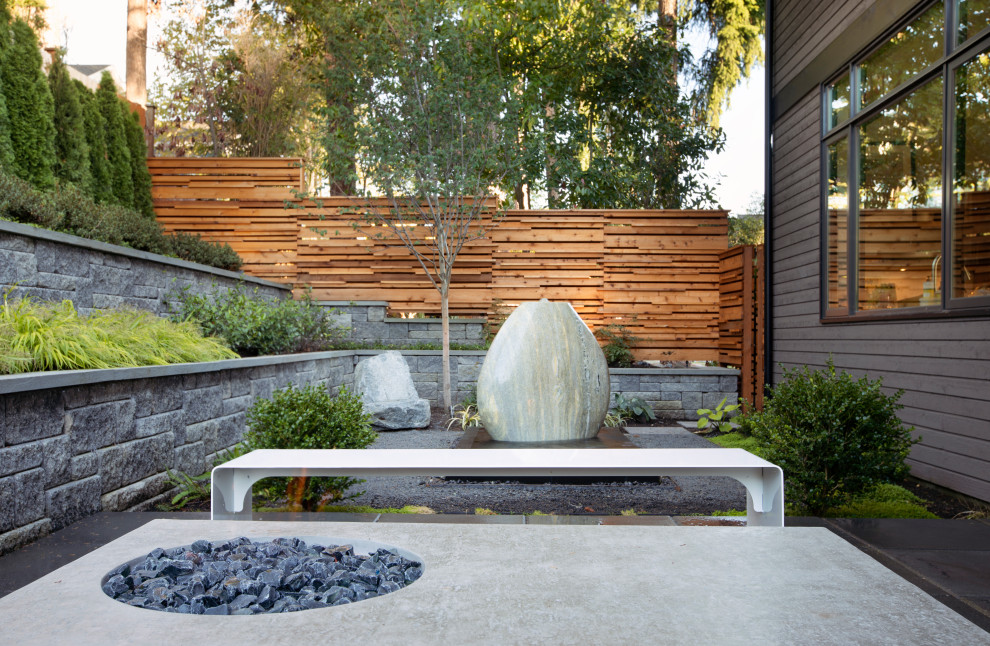 Photo of a mid-sized modern backyard full sun formal garden in Seattle with with rock feature.