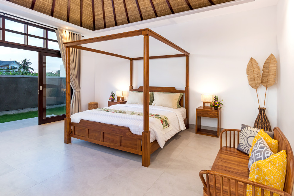 Foto di una camera da letto tropicale con pareti bianche, pavimento grigio, travi a vista e soffitto a volta