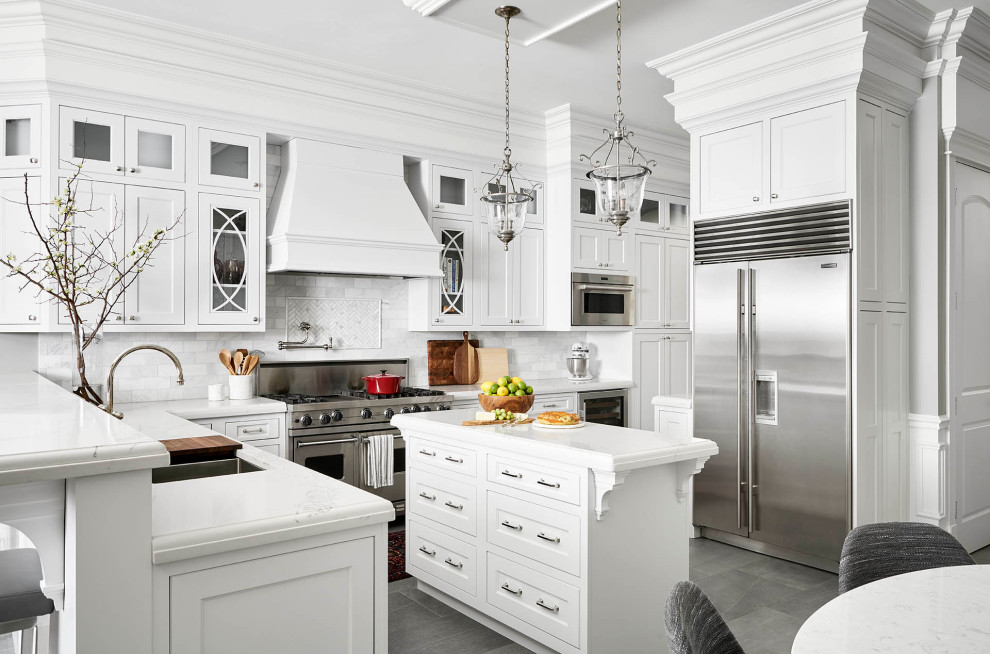 Inspiration for a mid-sized transitional u-shaped gray floor eat-in kitchen remodel in Chicago with an undermount sink, shaker cabinets, white cabinets, gray backsplash, subway tile backsplash, stainless steel appliances, an island and white countertops
