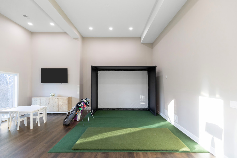 This is an example of an expansive modern walk-out basement in Kansas City with beige walls.