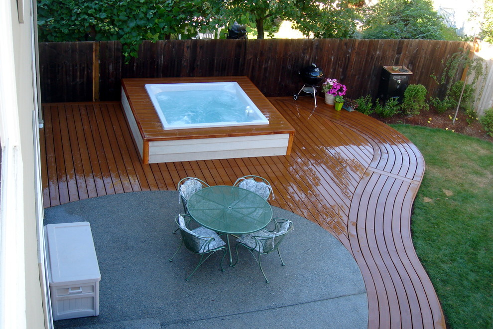 Example of a transitional backyard patio fountain design in Seattle with no cover and decking