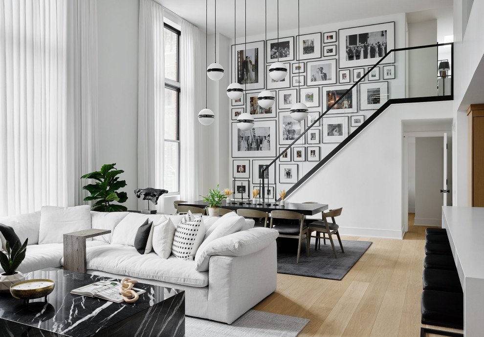 Inspiration pour un très grand salon minimaliste ouvert avec un mur blanc, parquet clair, aucune cheminée et aucun téléviseur.