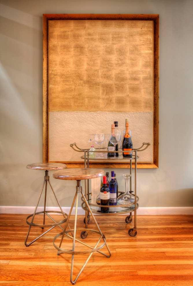 Photo of a small traditional bar cart in New York with glass benchtops and light hardwood floors.