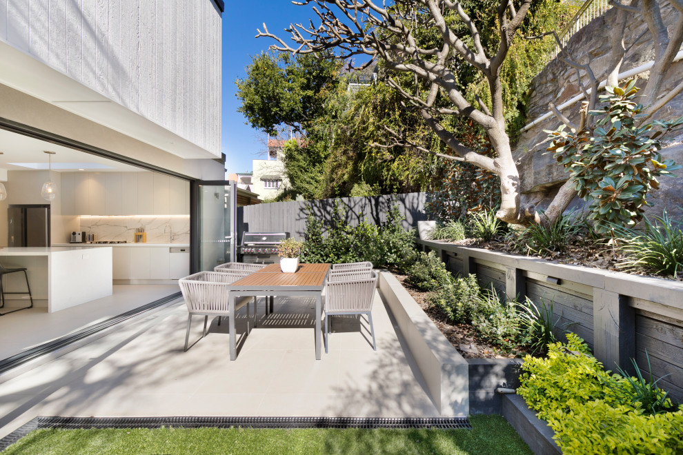 Photo of a transitional backyard garden in Sydney with with rock feature.