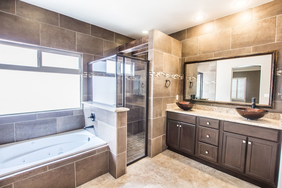 Large transitional master beige tile and ceramic tile ceramic tile corner bathtub photo in Austin with raised-panel cabinets, brown cabinets, brown walls, a vessel sink and granite countertops