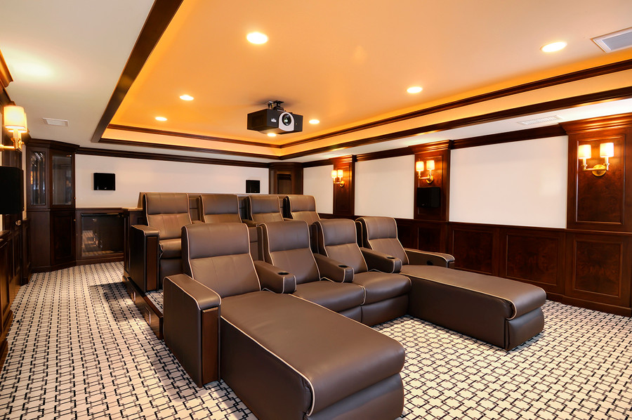 Large modern enclosed home theatre in San Diego with multi-coloured walls, carpet, a projector screen and multi-coloured floor.