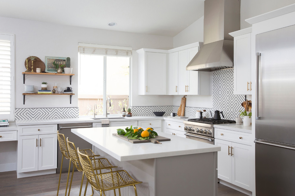 Design ideas for a mid-sized transitional l-shaped open plan kitchen in Denver with shaker cabinets, white cabinets, white splashback, stainless steel appliances, with island, brown floor, quartz benchtops, cement tile splashback, dark hardwood floors and an undermount sink.