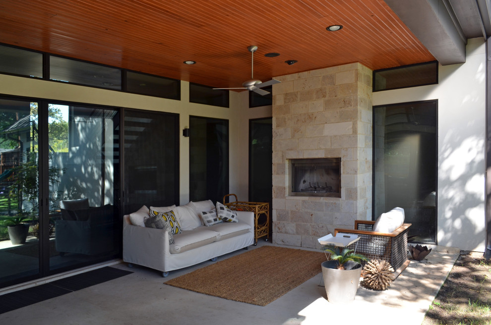 This is an example of a mid-sized modern backyard patio in Dallas with concrete slab and a roof extension.