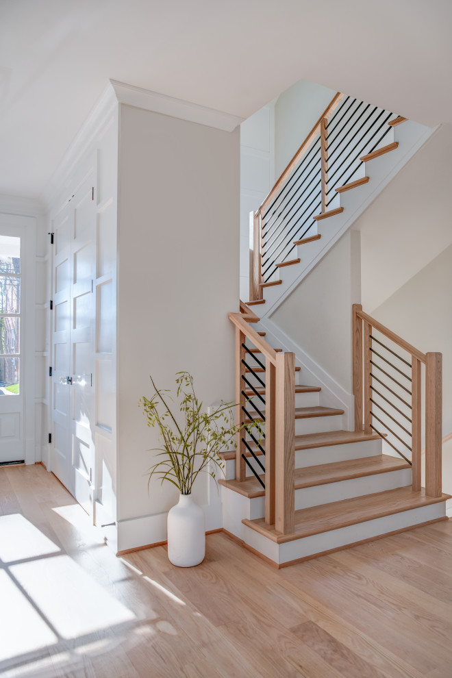 Imagen de escalera en U campestre grande con escalones de madera, contrahuellas de madera pintada y barandilla de varios materiales