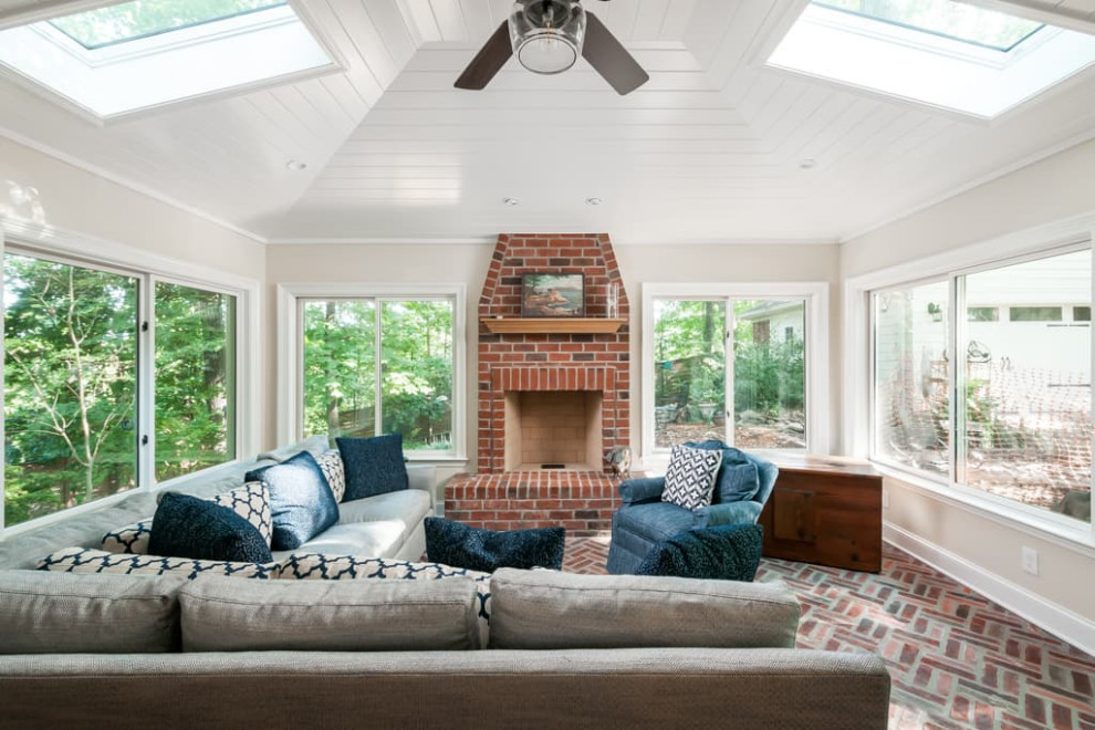 This is an example of a large traditional sunroom in Atlanta with brick floors, a standard fireplace, a brick fireplace surround, a skylight and red floor.